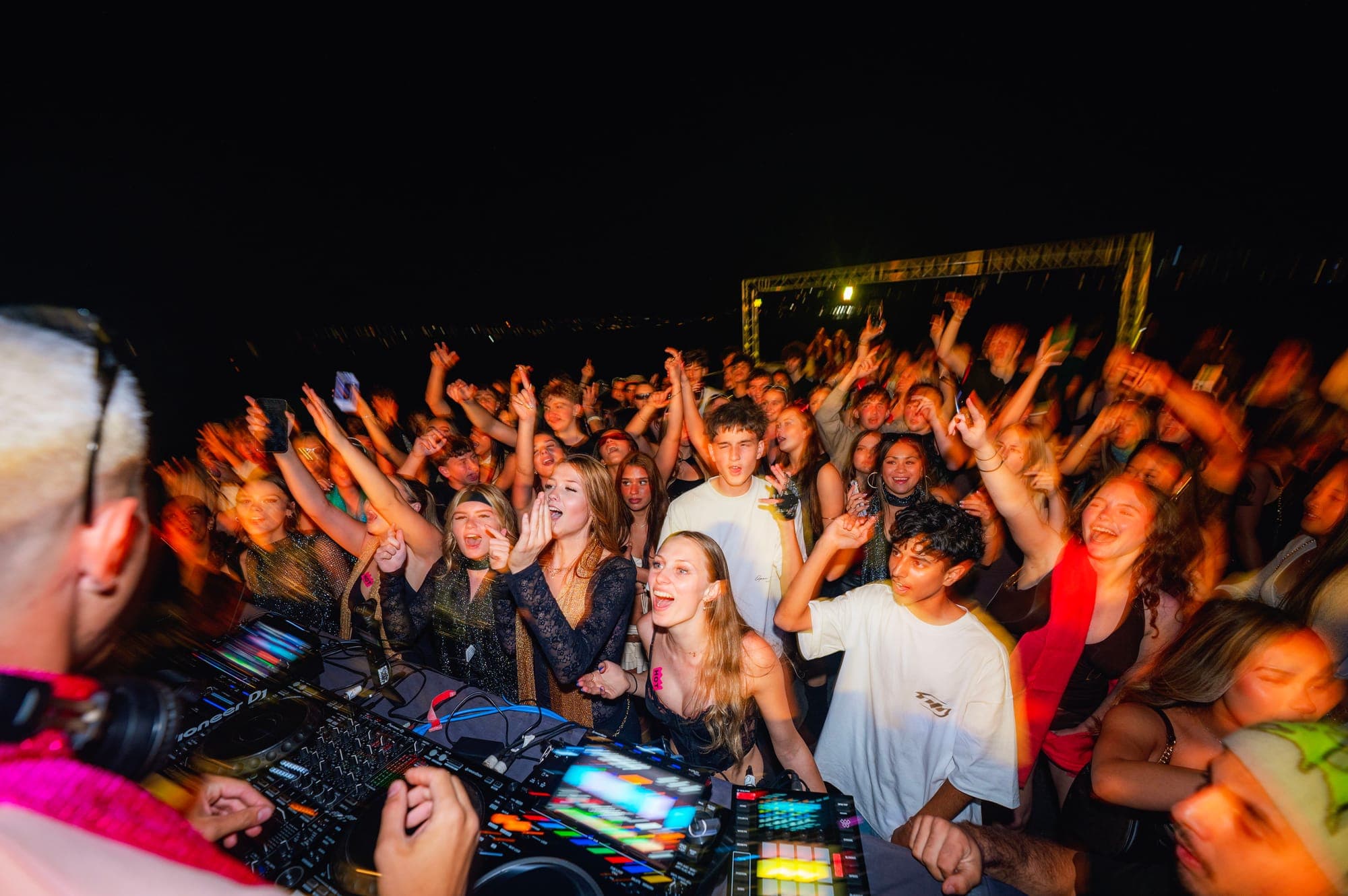 A DJ playing to a packed dancefloor on a previous boat party